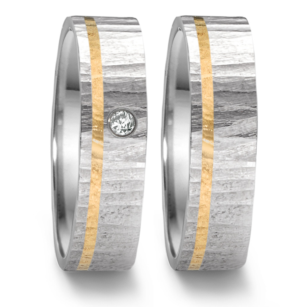 Partnerring Dieser markante Partnerring aus der Tamor Kollektion von TeNo mit "OAKTREE" Struktur besteht aus 18 Kt. Gelbgold mit Edelstahl und einem Diamanten mit 0.04 Carat im Vollschliff. Die Einkerbungen erinnern an die Rinde eines Baumes und entstehen in aufwendiger Handarbeit. Durch das besondere Design und die Verwendung hochwertiger Materialien vereint dieser Ring symbolische Bedeutung mit individuellem Stil. 468.1314.D30.XX