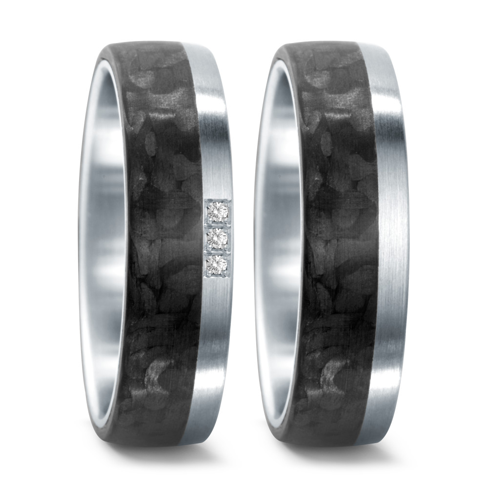 Partnerring Dieser TeNo Design Ring verkörpert zeitlose Eleganz und Langlebigkeit in einer markanten Formsprache. Die einzigartige Kombination aus Edelstahl und leichtem Carbon, zusammen mit drei funkelnden Diamanten mit einem Gesamtgewicht von 0,03 Karat, macht diesen 6,5 mm breiten Ring zu einem begehrten Schmuckstück. Die gewölbte Innenseite gewährleistet einen bequemen Sitz am Finger. Hergestellt in deutscher Manufaktur, bietet er nicht nur erstklassigen Komfort, sondern auch höchste Qualität. 