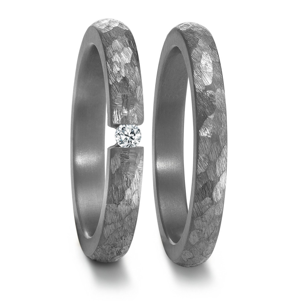 Partnerring Edler Damen Partnerring aus 999er Tantal mit markanter, facettierter Oberfläche. Der Ring ist mit einem funkelnden Diamanten besetzt, der für zeitlose Eleganz sorgt. Ein hochwertiges Schmuckstück, symbolisiert Liebe und Beständigkeit in stilvollem Design.
